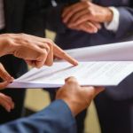 manos de abogados leyendo una normativa